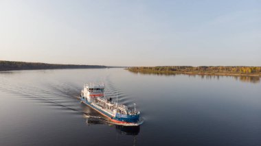 Mavnalarla nehir boyunca yük arabalarını taşırlar. Pürüzsüz su, akşam ışığı