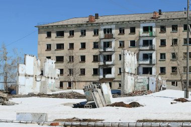 Boş pencereleri olan terk edilmiş bir apartman. yakınlardaki beton levhalar