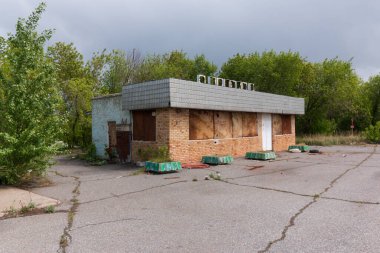 Asfalttaki ormanın yanındaki terk edilmiş bina.