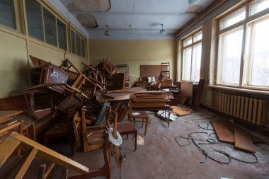 Masaları ve rafları olan terk edilmiş bir sınıf.
