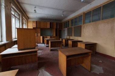 Masaları ve rafları olan terk edilmiş bir sınıf.