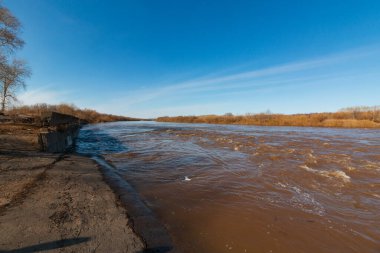 spilled river banks in autumn with blue sky