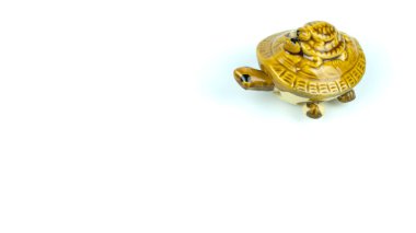 Beyaz arka planda sarı kaplumbağa. Sarı kaplumbağanın seramik biblosu. Yazı için arkaplan. Şans tılsımı, para