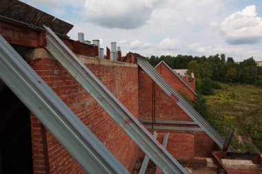 Evin çatısının metal çerçevesi. Bitmemiş tuğla bina. apartman çatısı yapısı