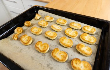 Fırından hazır kurabiyeler, fırın tepsisi, kurabiye kulakları, lezzetli ev yapımı kekler, evdeki mutfakta pişirme.