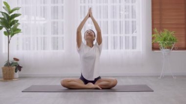 Spor giyim bölümünde çalışan Asyalı bir kadın fitness stüdyosunda sağlıklı yaşam tarzını geliştiriyor..