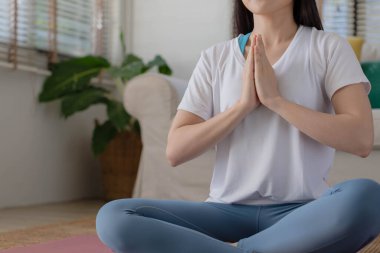 Asyalı bir kadınla sabah yogası, kolay bir pozisyonda oturmak, Sukhasana duruşu ve internette meditasyon yapmak..