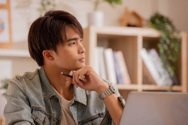 Asyalı tasarımcı sabah evde oturup tasarımı düşünüyor..