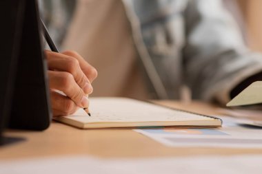 Kapat elini Asyalı adam kalem kullan ve not işini masa üstüne yaz, evden çalış.