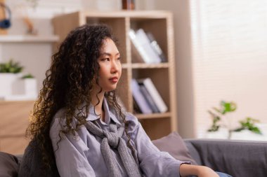 Asyalı bir tasarımcı, evdeki kanepede otururken büyük başarılar ve tutkular nedeniyle keyfi yerindedir..