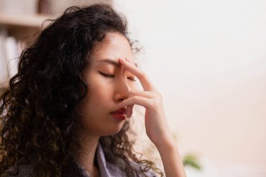 Nefesini yönlendirmek için, Asyalı bir kadın parmaklarıyla alnına dokunur. Yoga ve meditasyona başlamak için.