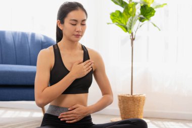 Asyalı kadın sabah yogası yapıyor, kolay pozisyonda oturuyor, Sukhasana duruşu ve meditasyon yapıyor..