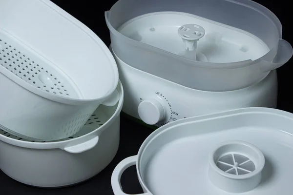 Siyah arka planda yemek buharı. Sağlıklı yemek hazırlamak için ev aletleri..