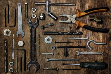 Ahşap bir arka planda eski aletlerin koleksiyonu. Tamir ve inşaat işi kavramı. Eski ve paslı aletler.