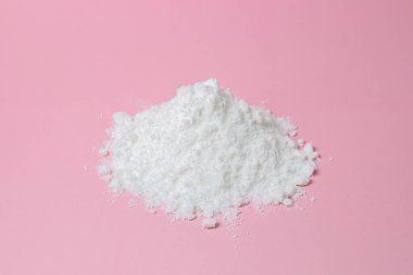 İzole edilmiş toz şeker. Pembe arka planda şeker tozu. Pişirme malzemesi.