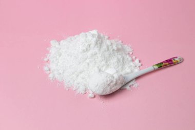 İzole edilmiş toz şeker. Pembe arka planda şeker tozu. Pişirme malzemesi.