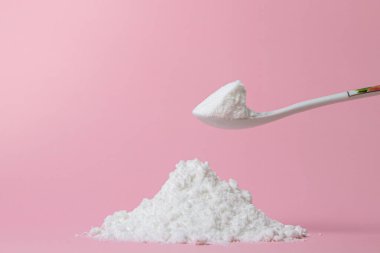 İzole edilmiş toz şeker. Pembe arka planda şeker tozu. Pişirme malzemesi.