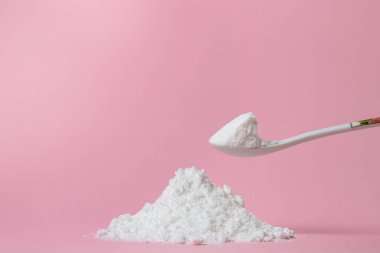 İzole edilmiş toz şeker. Pembe arka planda şeker tozu. Pişirme malzemesi.