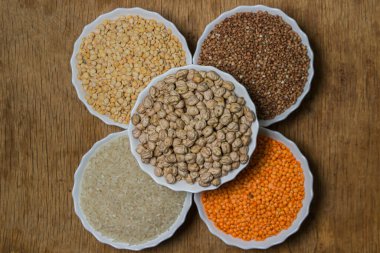 Tahta arka planda çeşitli mısır gevrekleri. Sağlıklı yemek kavramı. Vejetaryen yemeği.