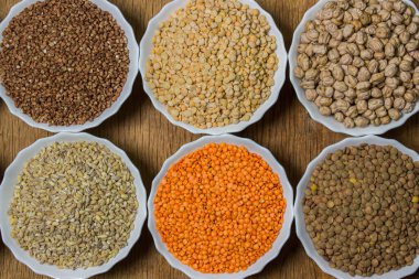 Tahta arka planda çeşitli mısır gevrekleri. Sağlıklı yemek kavramı. Vejetaryen yemeği.