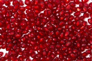 Beyaz arka planda nar tohumları. Ekranda soyulmuş nar.