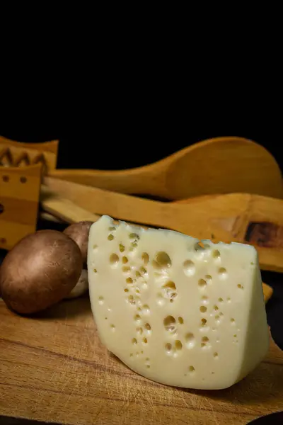 Gelber Käse Auf Schwarzem Hintergrund Scheibenkäse Neben Rohen Pilzen Auf — Stockfoto