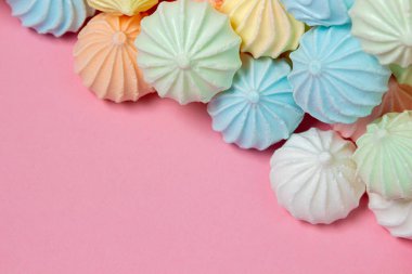 Pembe arka planda çok renkli kremalar. Parlak arkaplanda bir yığın krema var. Kopya alanı için bir yer var.