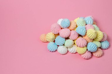 Pembe arka planda çok renkli kremalar. Parlak arkaplanda bir yığın krema var. Kopya alanı için bir yer var.