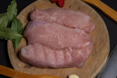 Siyah arka planda çiğ hindi bifteği. Tahtada hindi göğsü filetosu. Diyet et