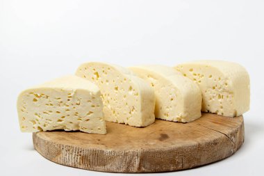 Beyaz arka planda beyaz peynir. Tahtada ev yapımı beyaz peynir. Geleneksel mutfak