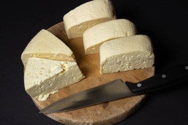 Siyah arka planda beyaz peynir. Tahtada ev yapımı beyaz peynir. Geleneksel mutfak