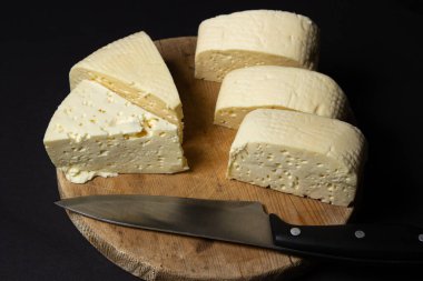 Siyah arka planda beyaz peynir. Tahtada ev yapımı beyaz peynir. Geleneksel mutfak