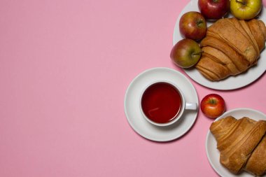 Beyaz bir masada lezzetli ve sağlıklı bir kahvaltı. Bir fincan çay, hamur işi ve meyveli..