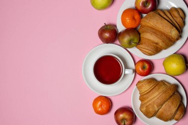 Beyaz bir masada lezzetli ve sağlıklı bir kahvaltı. Bir fincan çay, hamur işi ve meyveli..