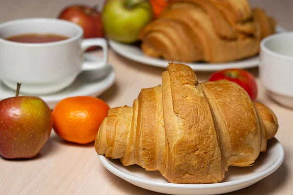 Beyaz bir masada lezzetli ve sağlıklı bir kahvaltı. Bir fincan çay, hamur işi ve meyveli..