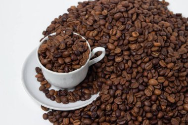 Beyaz arka planda kahve çekirdekleri. Kahve çekirdeği dolu bir kahve fincanı. Büyük boy kafein.