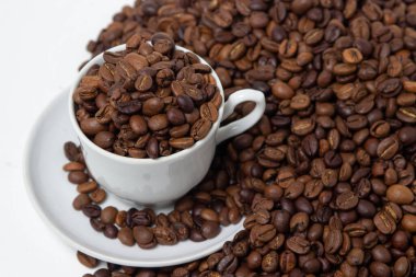 Beyaz arka planda kahve çekirdekleri. Kahve çekirdeği dolu bir kahve fincanı. Büyük boy kafein.