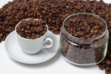 Beyaz arka planda kahve çekirdekleri. Kahve çekirdeği dolu bir kahve fincanı. Büyük boy kafein.