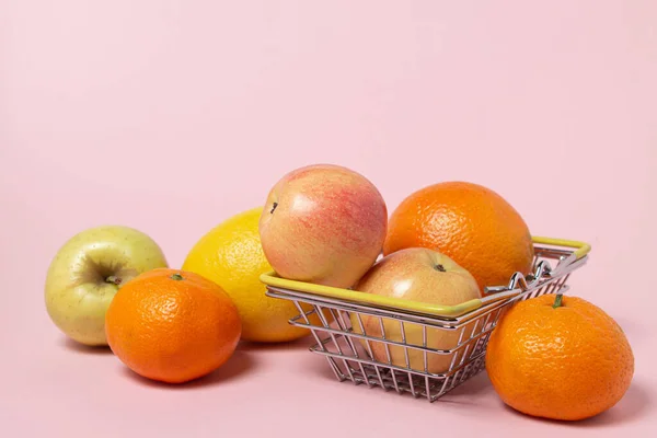 粉色背景的小购物篮里的水果 买水果 超级市场购物概念 — 图库照片