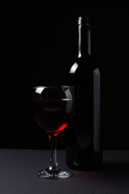 Siyah arka planda üç kadeh kırmızı şarap. Alkolik içki..