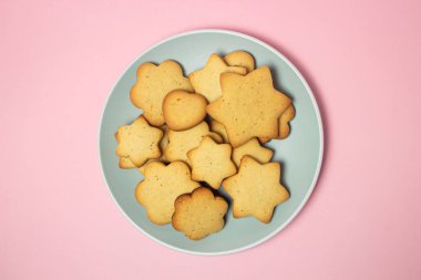 Pembe arka planda ev yapımı kurabiye. Lezzetli ve hafif tatlı. Tabaktaki kurabiyeler.