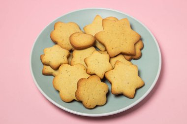 Pembe arka planda ev yapımı kurabiye. Lezzetli ve hafif tatlı. Tabaktaki kurabiyeler.