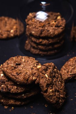 Siyah arka planda çikolata parçacıklı kurabiyeler. Tatlı çikolatalı şeker. Ev yapımı kurabiyeler