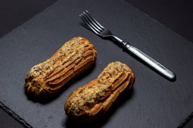 Siyah tabaklarda ve siyah arka planda ekler. Tatlı ve lezzetli bir tatlı. Güzel bir tatlı.