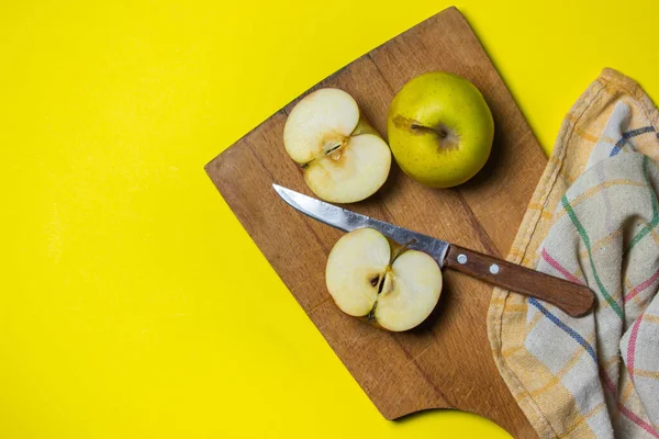Sarı arka planda elmalar. Tahtadaki elmanın yarısı..