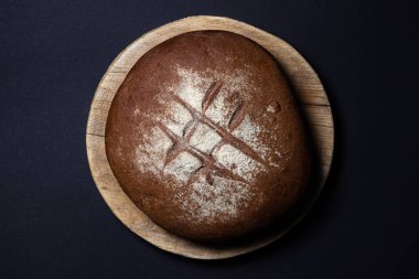 Siyah arka planda ekmek. Tahtada taze ev yapımı ekmek. Geleneksel yemek.