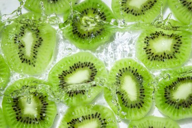 Kivi suyu beyaz arka planda dilimler. Soyulmuş ve dilimlenmiş kivi..