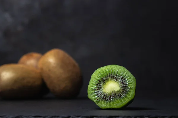 Siyah arka planda Kivi. Kivi ikiye bölündü. Taze ve olgun meyve.