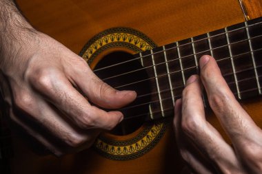Eller akustik gitar çalıyor. Gitarı yakından çalıyorum. Müzik hobisi