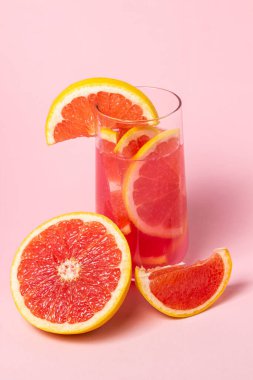 Pembe arka planda greyfurtlu pembe kokteyl. Tatlı meyve kokteyli. Lezzetli içecek